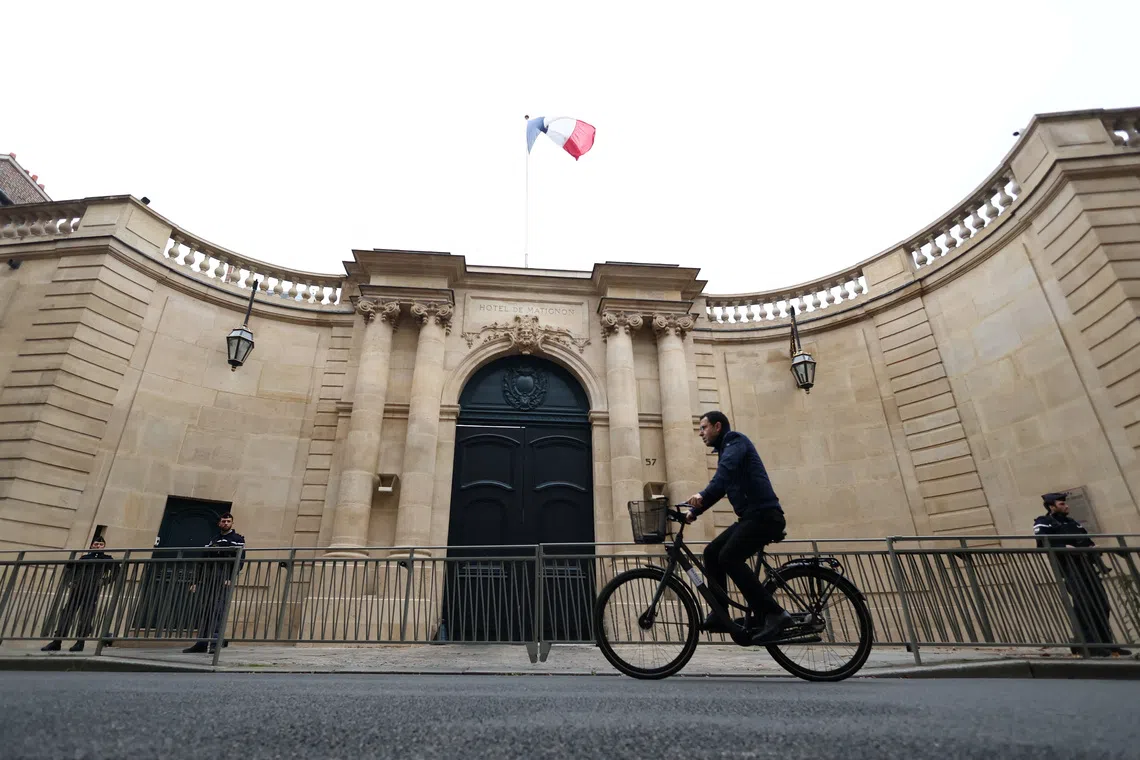 A man rides his bicycle in front of the Hotel Matignon, following a statement by French outgoing Prime Minister Sebastien Lecornu, who presented his government's resignation to the French president this morning, in Paris, France, October 6, 2025. REUTERS/Stephane Mahe