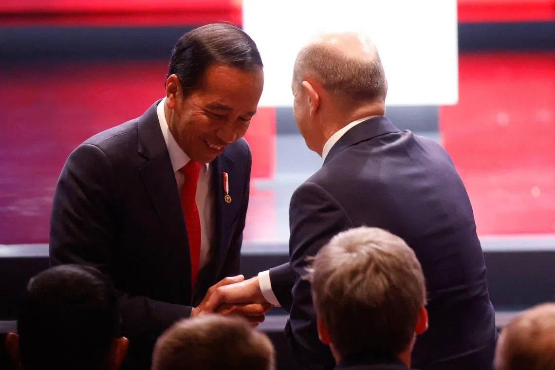 German Chancellor Olaf Scholz shakes hands with Indonesia's President Joko Widodo during the opening ceremony of the Hanover technology fair (Hannover Messe) on April 16, 2023. (Photo by Axel Heimken / AFP)