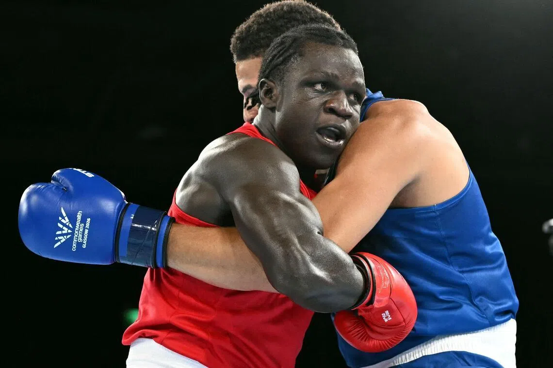 Uganda’s Aziz Abdul (in red) was disqualified for a headbutt in the third round of his opening super-heavyweight bout against England’s Damar Thomas.