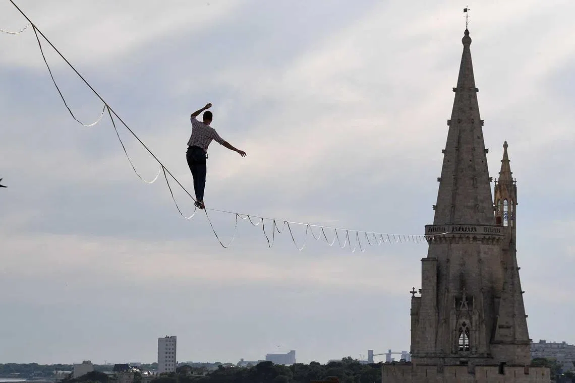 Tightrope walker Nathan Paulin performs on a 50-metre-high and 277-metre-long rope between the Lantern Tower and the Saint-Nicolas Tower above the old port in La Rochelle, France, on June 7.