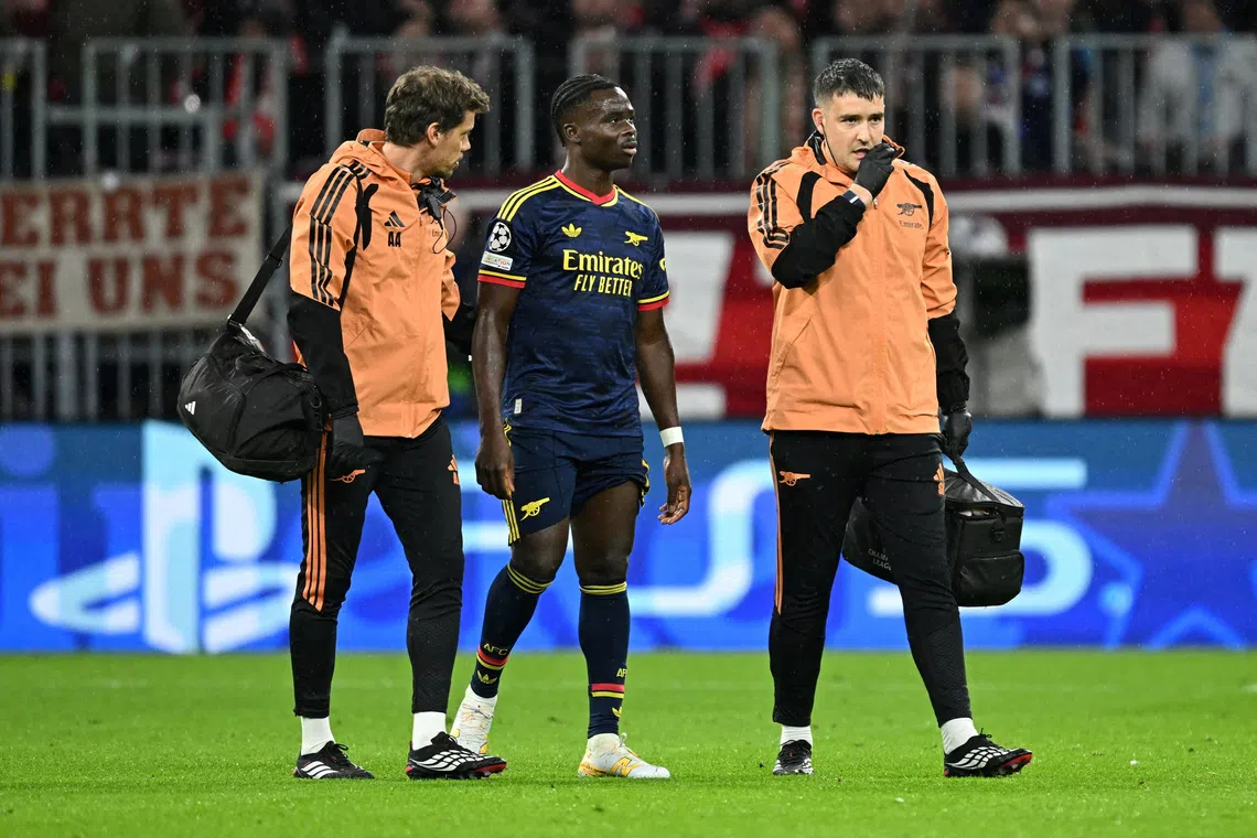 Soccer Football - UEFA Champions League - Bayern Munich v Arsenal - Allianz Arena, Munich, Germany - October 21, 2026  Arsenal's Bukayo Saka walks off the pitch as he is substituted after sustaining an injury REUTERS/Angelika Warmuth