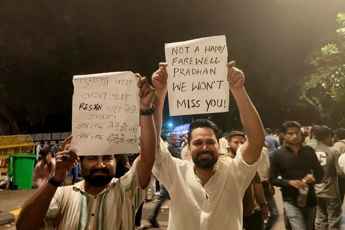 A reveller holding a banner celebrating the Indian education minister’s resignation on July 25 near the Jantar Mantar protest site.