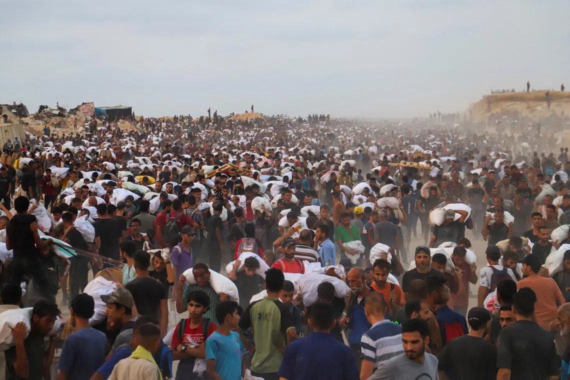 Palestinians carrying aid supplies, that entered Gaza on trucks through Israel, in Beit Lahia, in the northern Gaza Strip, on July 29, 2025. 