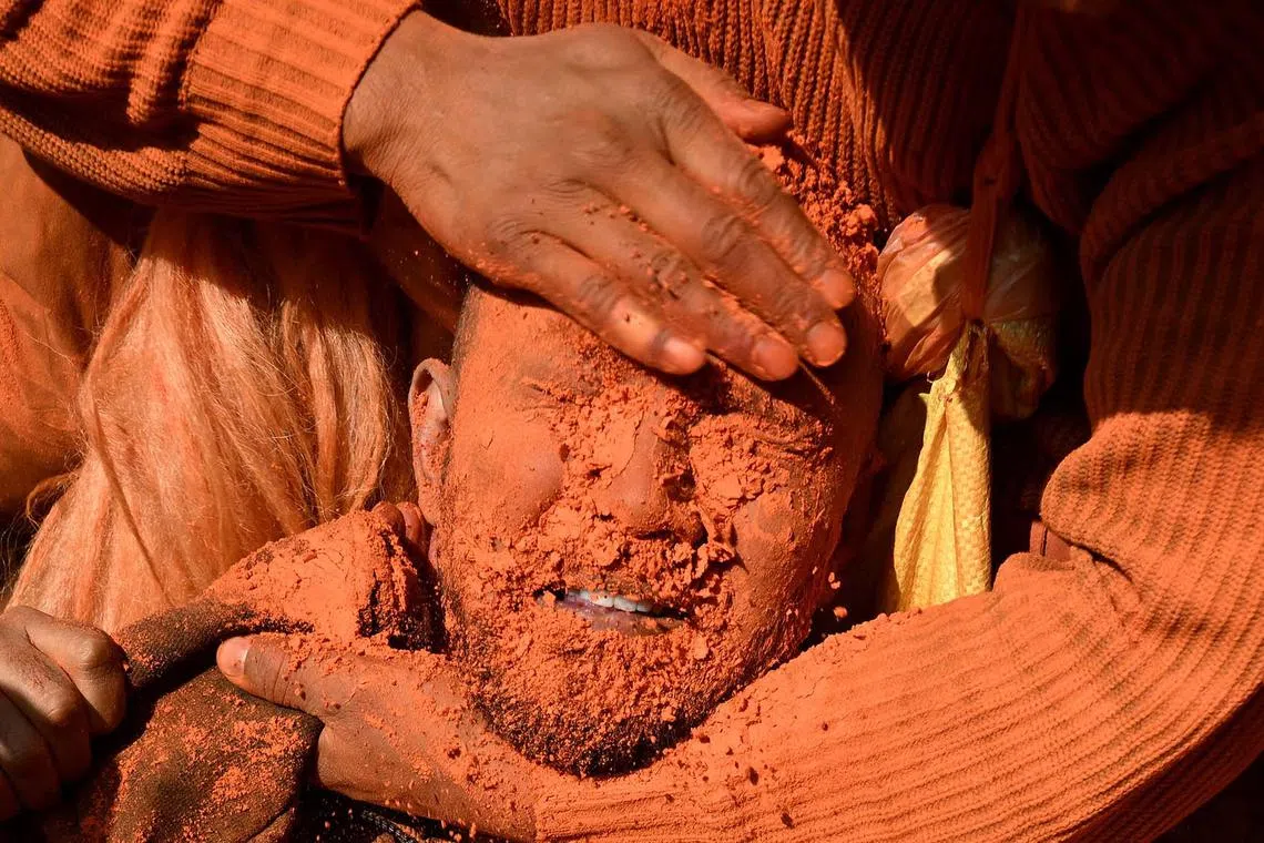 TOPSHOT - A reveller smeared in vermilion powder celebrates 'Bisket Jatra' festival that marks the Nepali New Year, in Thimi on the outskirts of Kathmandu on April 15, 2025. (Photo by PRAKASH MATHEMA / AFP)