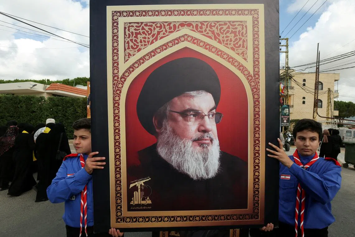 FILE PHOTO: Boys scouts carry a picture of Hezbollah leader Sayyed Hassan Nasrallah during the funeral of  Hezbollah member Ali Mohamed Chalbi, after hand-held radios and pagers used by Hezbollah detonated across Lebanon, in Kfar Melki, Lebanon September 19, 2024. REUTERS/Aziz Taher/File Photo