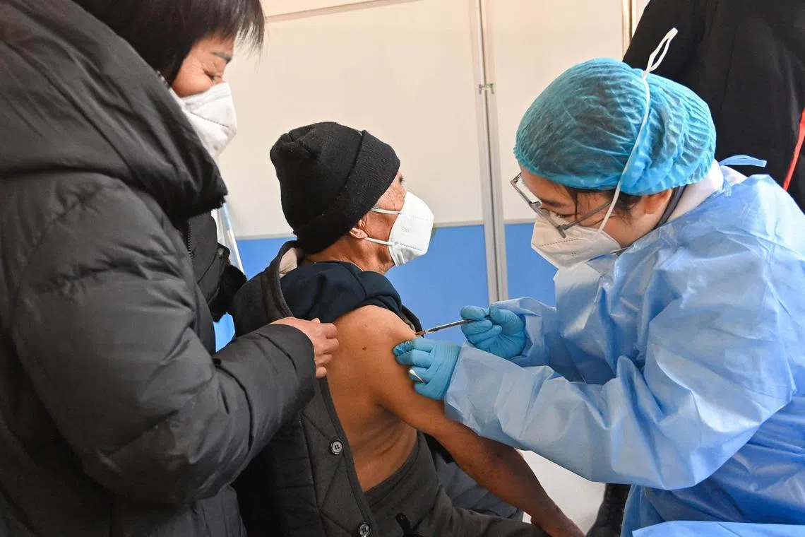 An elderly man receives a Covid-19 vaccine in Qingzhou in China's eastern Shandong province. IHME predicts cases in China would peak around Apr 1, when deaths would reach 322,000.