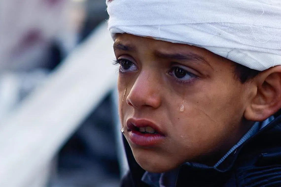 FILE PHOTO: A Palestinian boy, who was wounded in an Israeli strike, reacts at the site of an Israeli strike on a house, amid the ongoing conflict between Israel and the Palestinian Islamist group Hamas, in Rafah in the southern Gaza Strip, January 18, 2024. REUTERS/Mohammed Salem/File Photo
