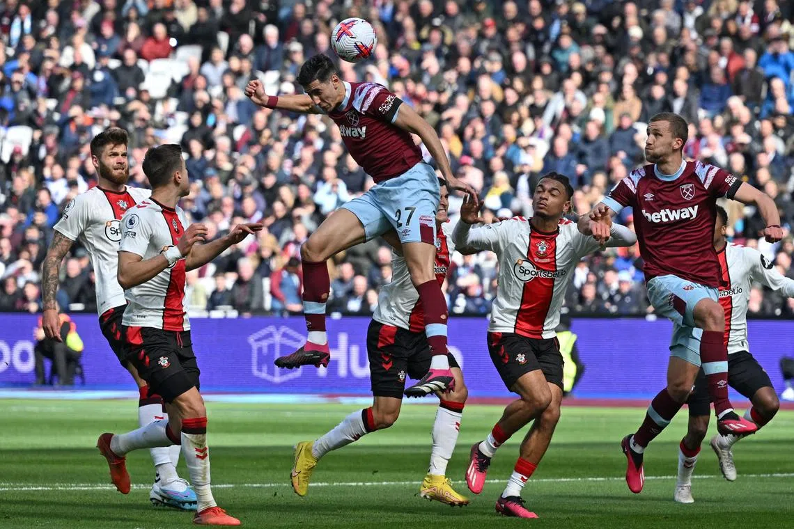 West Ham United's Moroccan defender Nayef Aguerd (centre) jumps to head home the opening goal in London, on April 2, 2023.