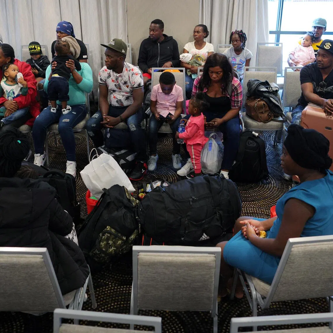 Immigrants from Haiti who recently arrived in Boston from other parts of the United States listen to instructions from representatives of La Colaborativa, a non-profit community services organization based in Chelsea, as they arrive at temporary housing in a hotel in Everett, Massachusetts, U.S., July 10, 2023.     REUTERS/Brian Snyder