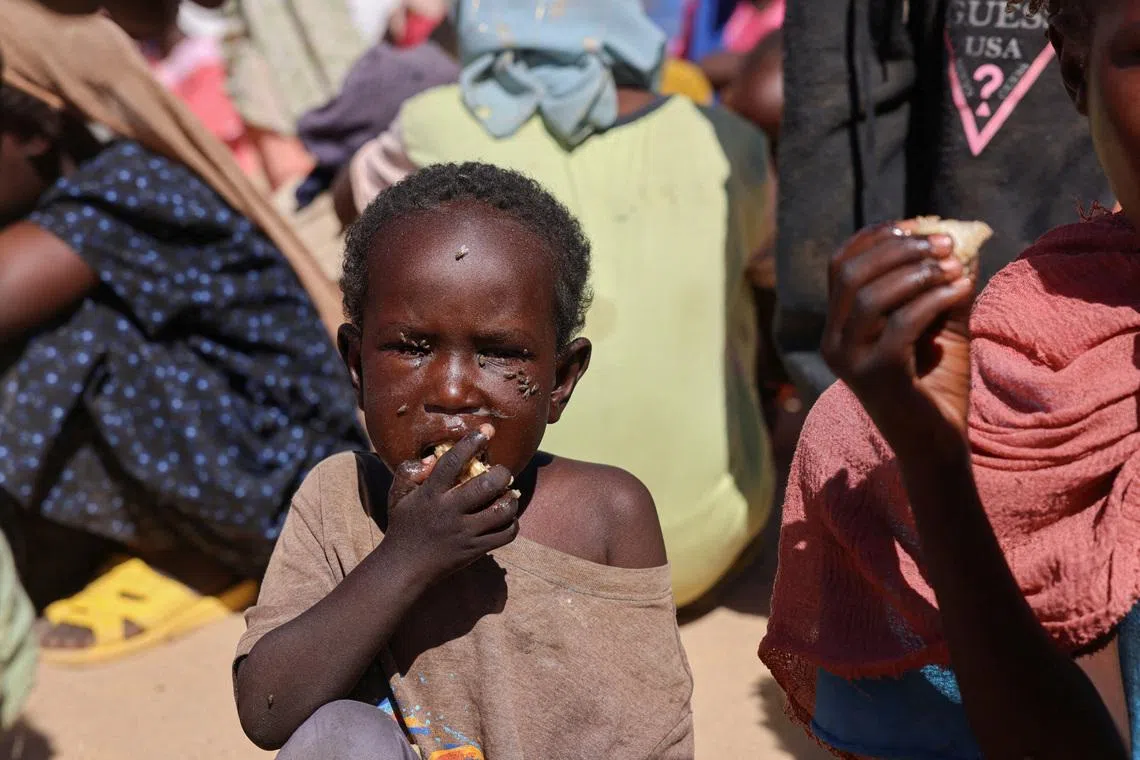 FILE PHOTO: A Sudanese refugee child from Al-Fashir eats a shared a meal at the Tine transit refugee camp, amid the conflict between the paramilitary Rapid Support Forces (RSF) and the Sudanese army, in eastern Chad, November 22, 2025. REUTERS/Amr Abdallah Dalsh/File Photo