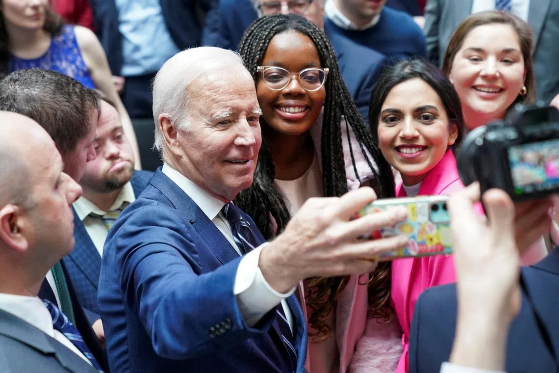 US President Joe Biden takes a selfie with students following the 25th anniversary of the Belfast/Good Friday Agreement, at Ulster University, Belfast, Northern Ireland. 