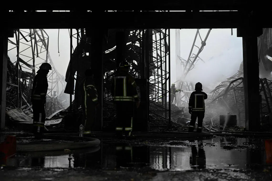 Rescuers work at the site of a Russian drone strike at a warehouse building in the Kyiv region on Dec 20.