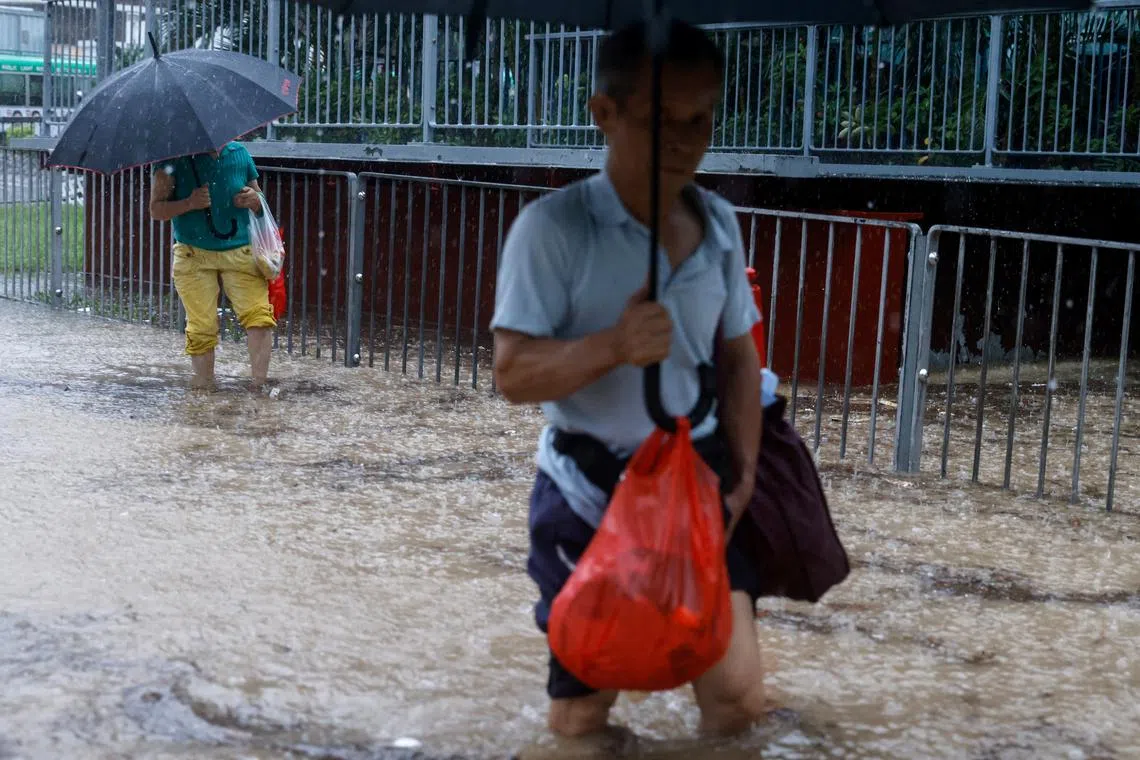 People making their way through a flooded area after heavy rains, in Hong Kong, China, Sept 8, 2023. 