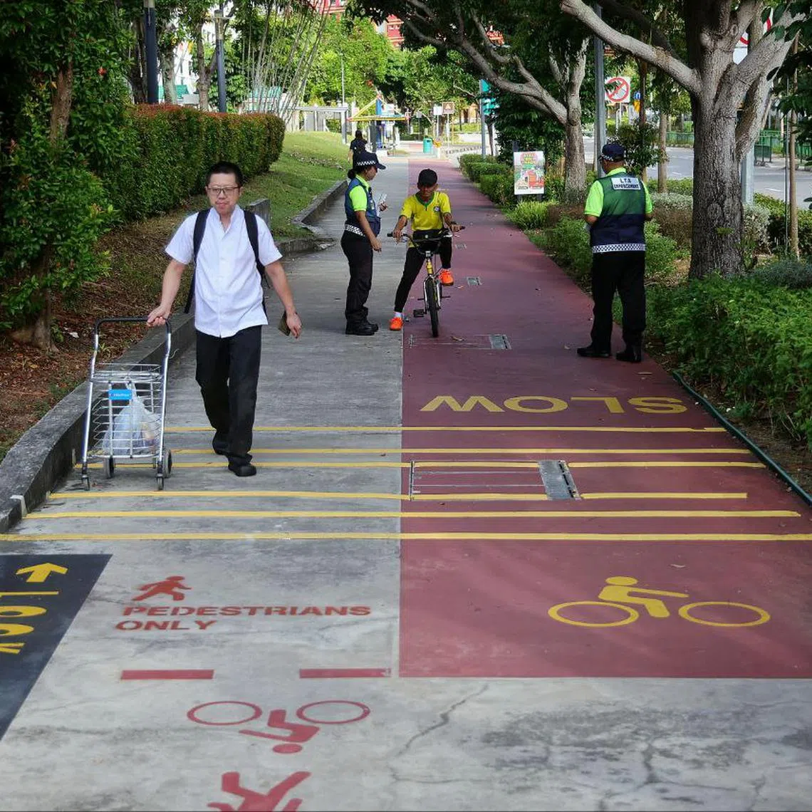 LTA’s active mobility enforcement officers advising pedestrians and cyclists to keep to their respective lanes on a newly converted 200m-long pedestrian-only path in Tampines on July 1.