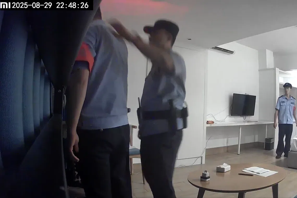 Police officers from Chongqing examining an empty hotel room where a projector flashing anti-Communist slogans was placed.