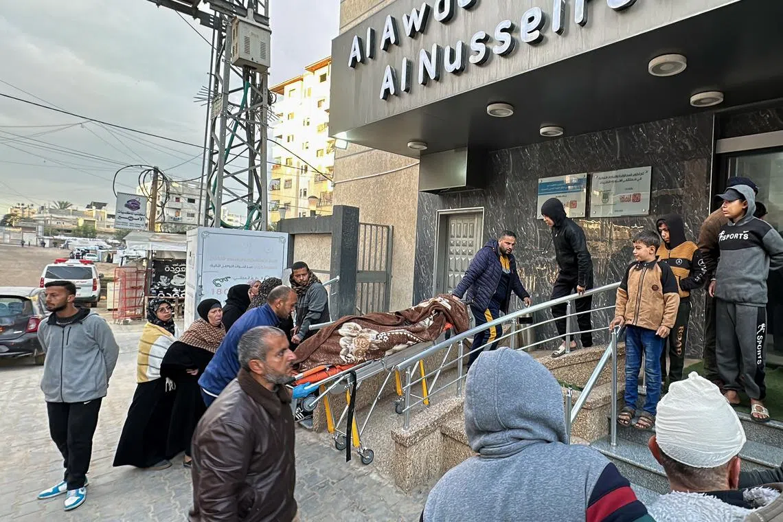 FILE PHOTO: People move the body of a Palestinian at a hospital after an Israeli strike, amid the ongoing conflict between Israel and Hamas, in Nuseirat in the central Gaza Strip, November 29, 2024. REUTERS/Khamis Said/File Photo