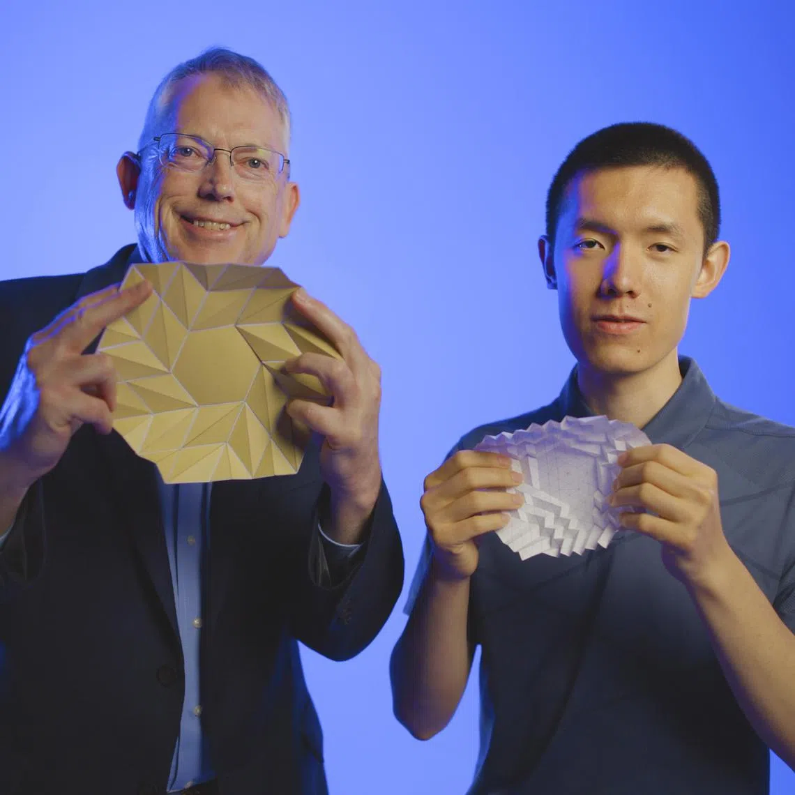 An undated photo provided by Brigham Young University shows, from left, Larry Howell, a professor of mechanical engineering at Brigham Young University and Kelvin Wang, a sophomore there. Researchers have now found a new class of origami that they call bloom patterns, which are rotationally symmetric around the center. (Brigham Young University via The New York Times) — NO SALES; FOR EDITORIAL USE ONLY WITH NYT STORY SLUGGED ORIGAMI PATTERN BY KENNETH CHANG FOR AUG. 19, 2025. ALL OTHER USE PROHIBITED. —