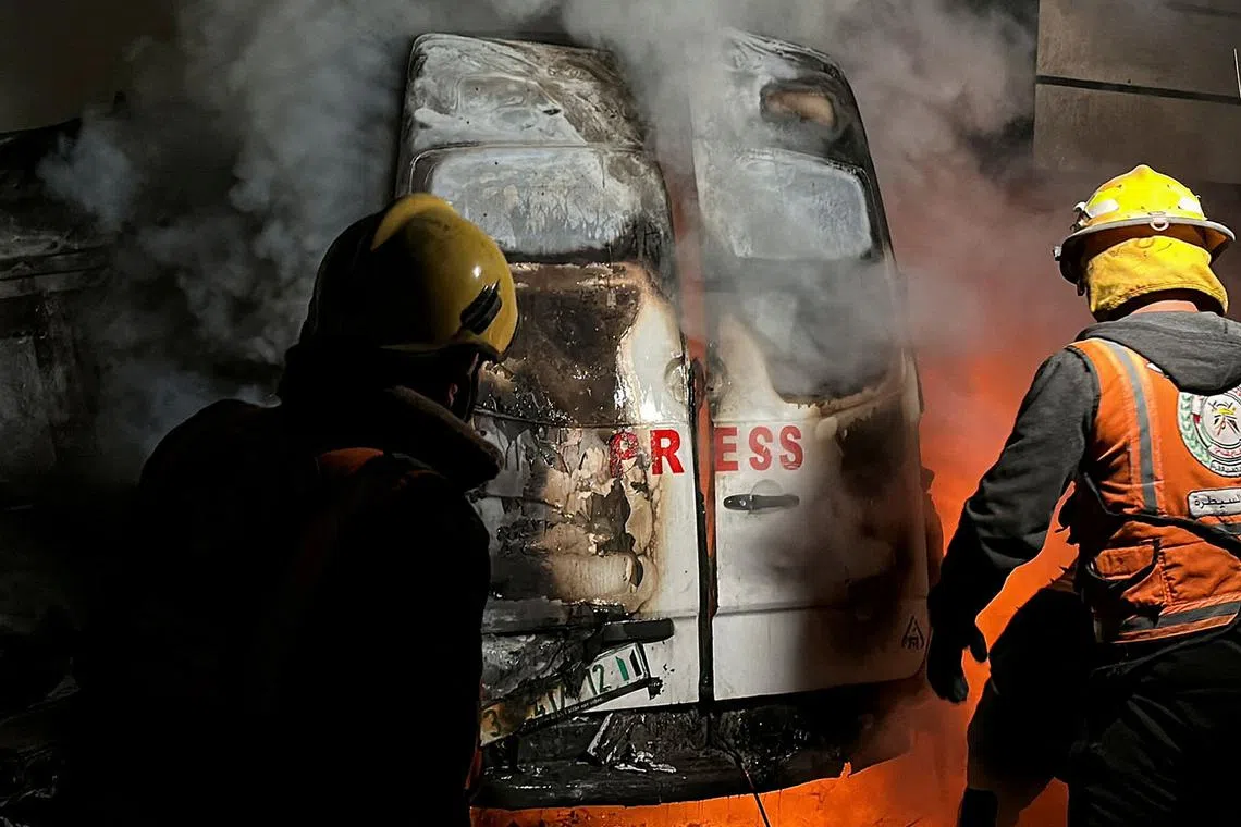 Civil Defense members put out a fire in a broadcast van following an Israeli strike that killed five journalists of Al-Quds Al-Youm television channel, according to medics with the Gaza health authorities, in the vicinity of Al-Awda hospital in Nuseirat in central Gaza December 26, 2024. REUTERS/Khamis Said TPX IMAGES OF THE DAY