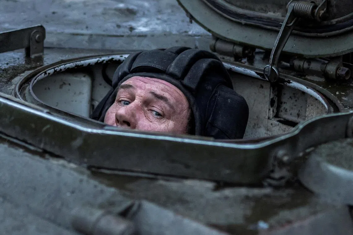 A Ukrainian serviceman of the 4th Ivan Vyhovskyi Separate Tank Brigade looks out from a self-propelled howitzer before firing towards Russian troops, near the front-line town of Kupyansk. 