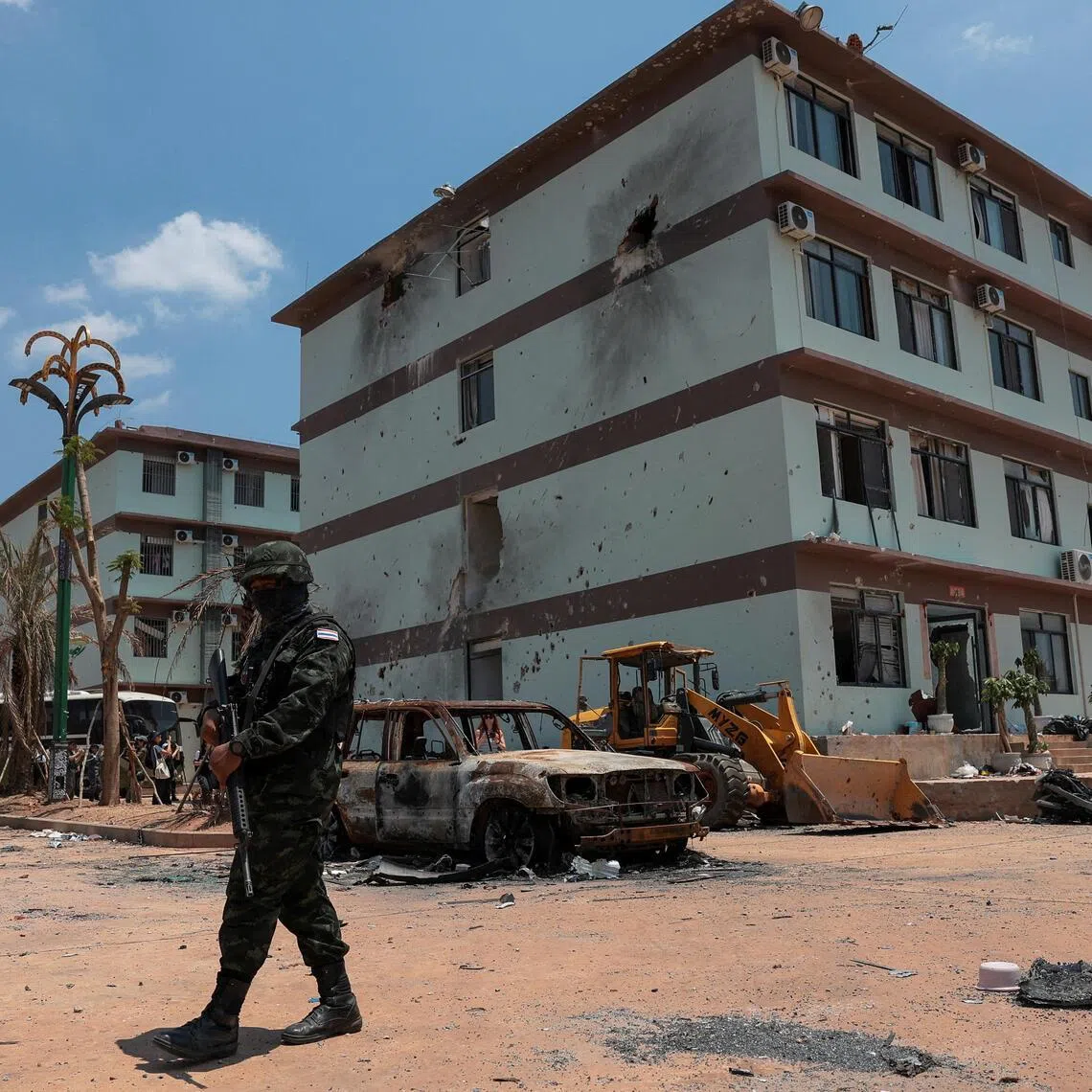 A Thai soldier stands guard near scam compounds, which the Thai military said were used for scam operations in the O’Smach area at the Chong Chom–O’Smach border crossing.