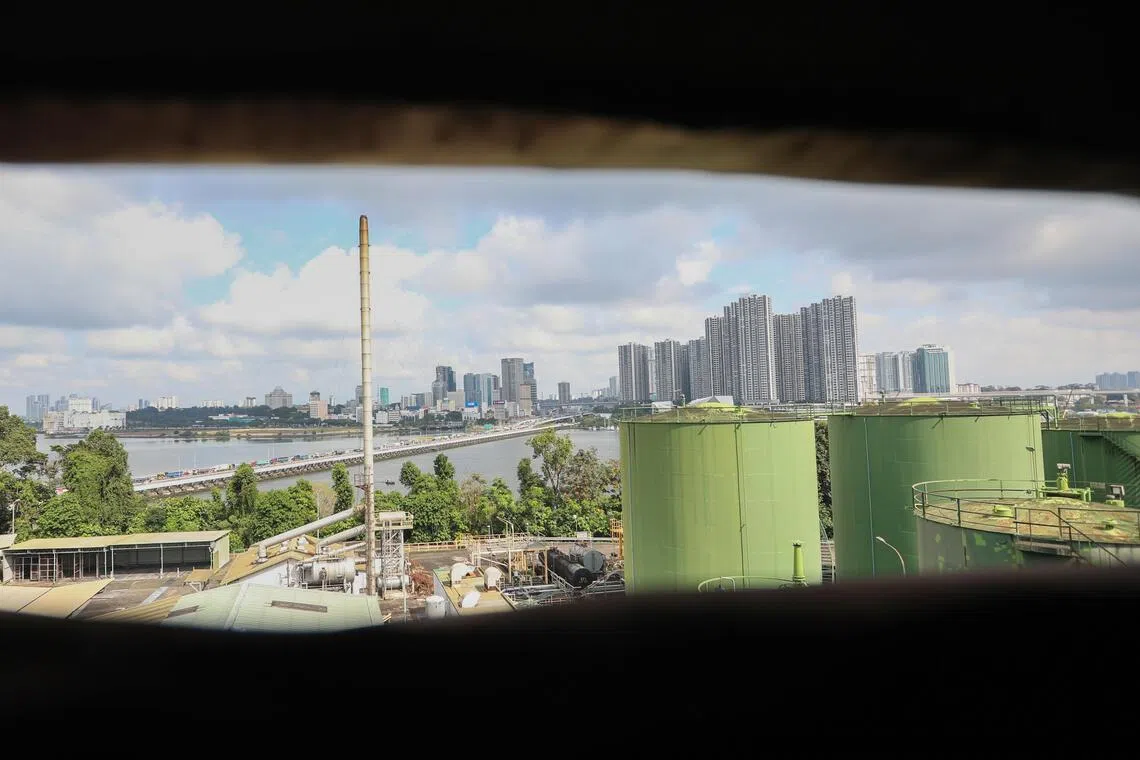 A view from a broken window slat of an old blending plant and the Causeway between Singapore and Malaysia. 