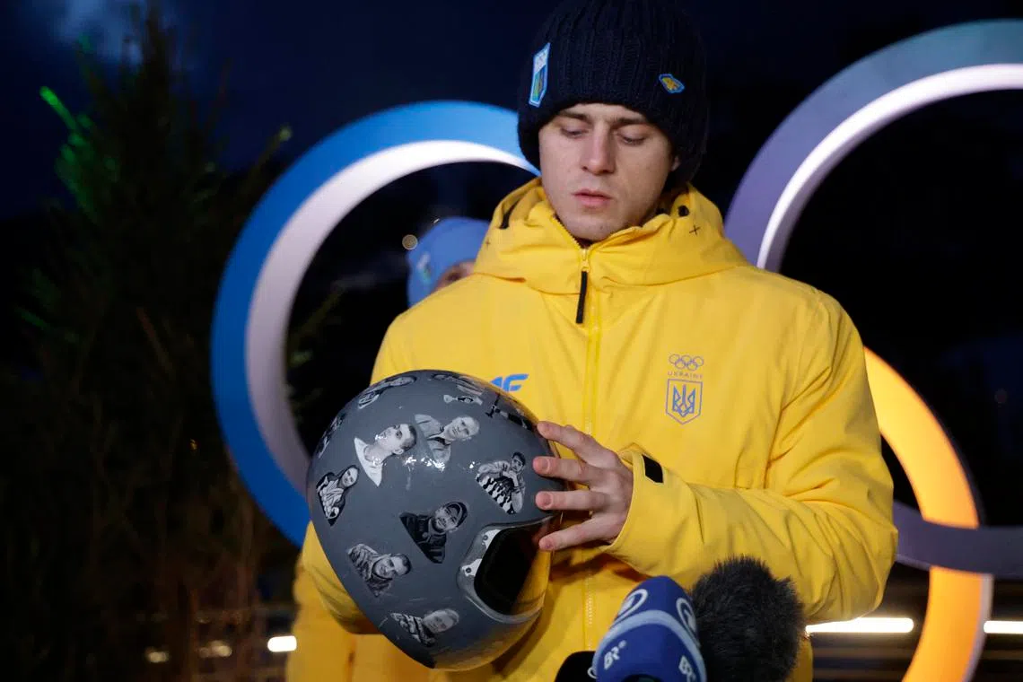 Milano Cortina 2026 Olympics - Skeleton - Vladyslav Heraskevych Press Conference - Cortina d'Ampezzo, Italy - February 10, 2026. Vladyslav Heraskevych of Ukraine displays his helmet that serves as a tribute to athletes who have died amid Russia's attack on Ukraine during the press conference REUTERS/Leonhard Foeger