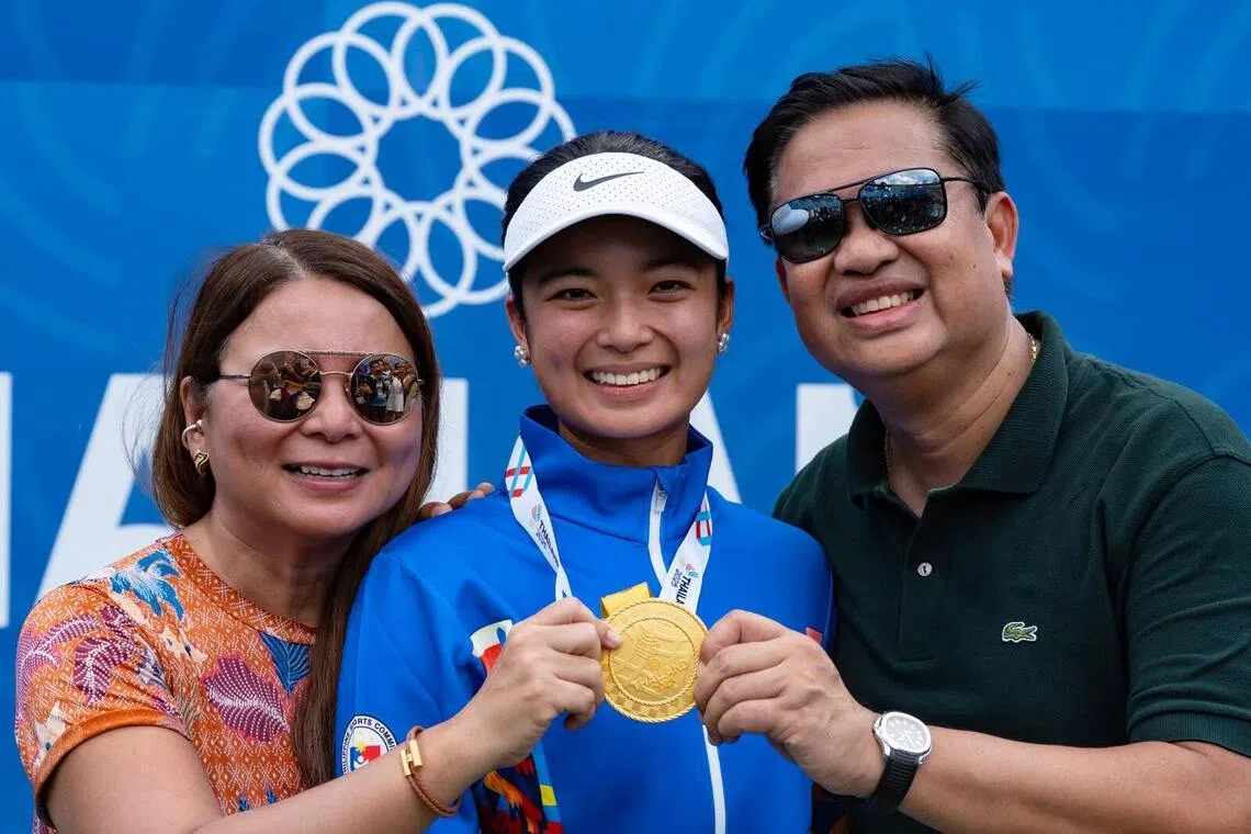 Alexandra Eala (centre) posing with her SEA Games women's singles medal with her mother Rizza Maniego-Eala (left) and father Mike on Dec 18, 2025.