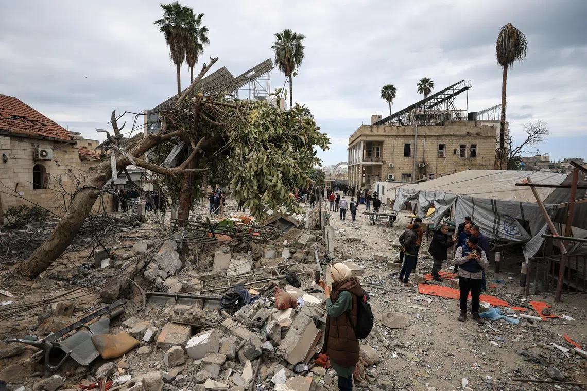 Palestinians inspect the damage after two Israeli missiles hit a building inside the Al-Ahli Arab Baptist Hospital, shortly after patients were evacuated following a call from someone who identified himself with Israeli security, in Gaza City, April 13, 2025. 

