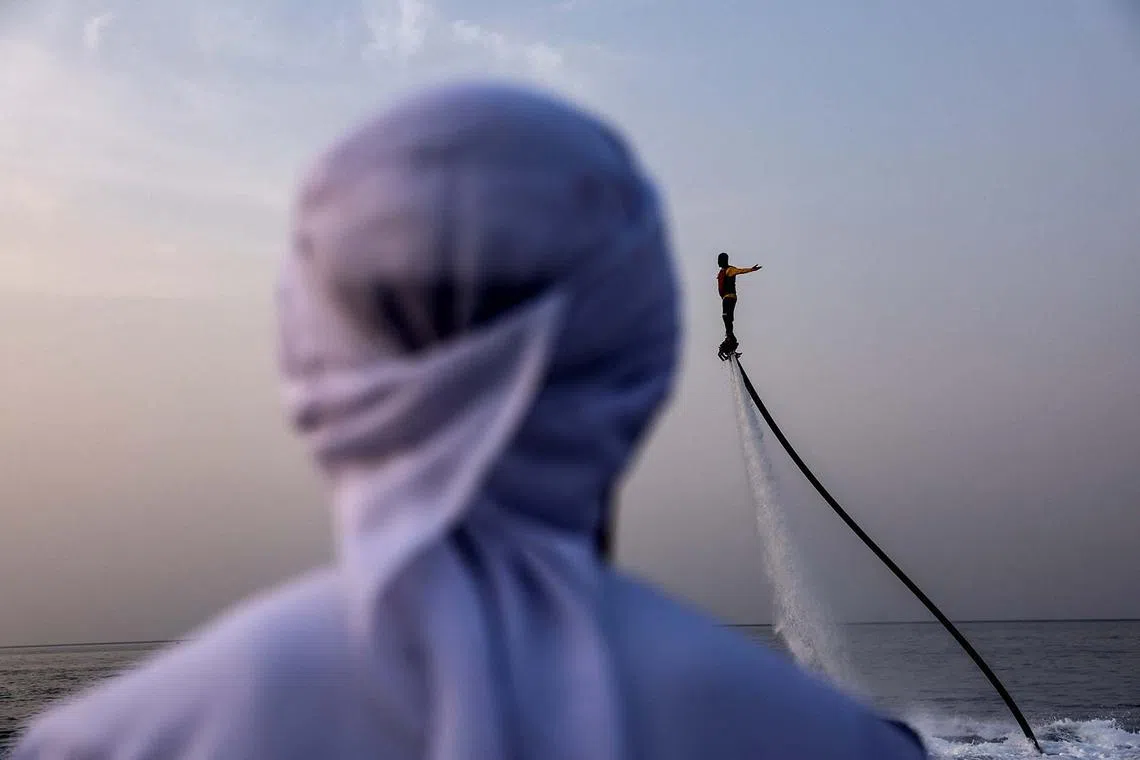 A man watching another man on a flyboard during a water show in Musandam, Oman, Aug 27, 2025. 
