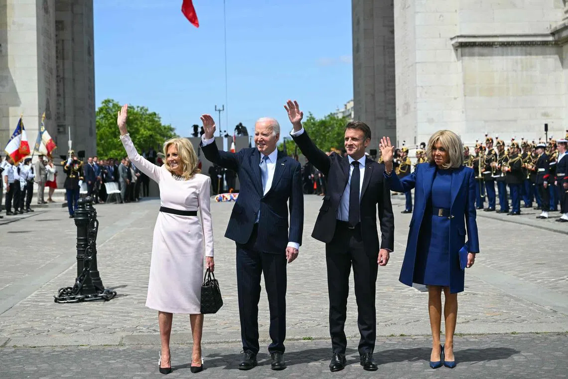 TOPSHOT - US President Joe Biden (C), flanked by US First Lady Jill Biden (L), France's President Emmanuel Macron (2ndR) and French president's wife Brigitte Macron (R), wave as he participates in a ceremony as part of a state visit to France, at the Arc de Triomphe in Paris on June 8, 2024. Biden is due to meet Macron for talks at the Elysee Palace in Paris followed by a state banquet given in his honour, with Ukraine's battle against the Russian invasion the dominant topic. (Photo by SAUL LOEB / AFP)