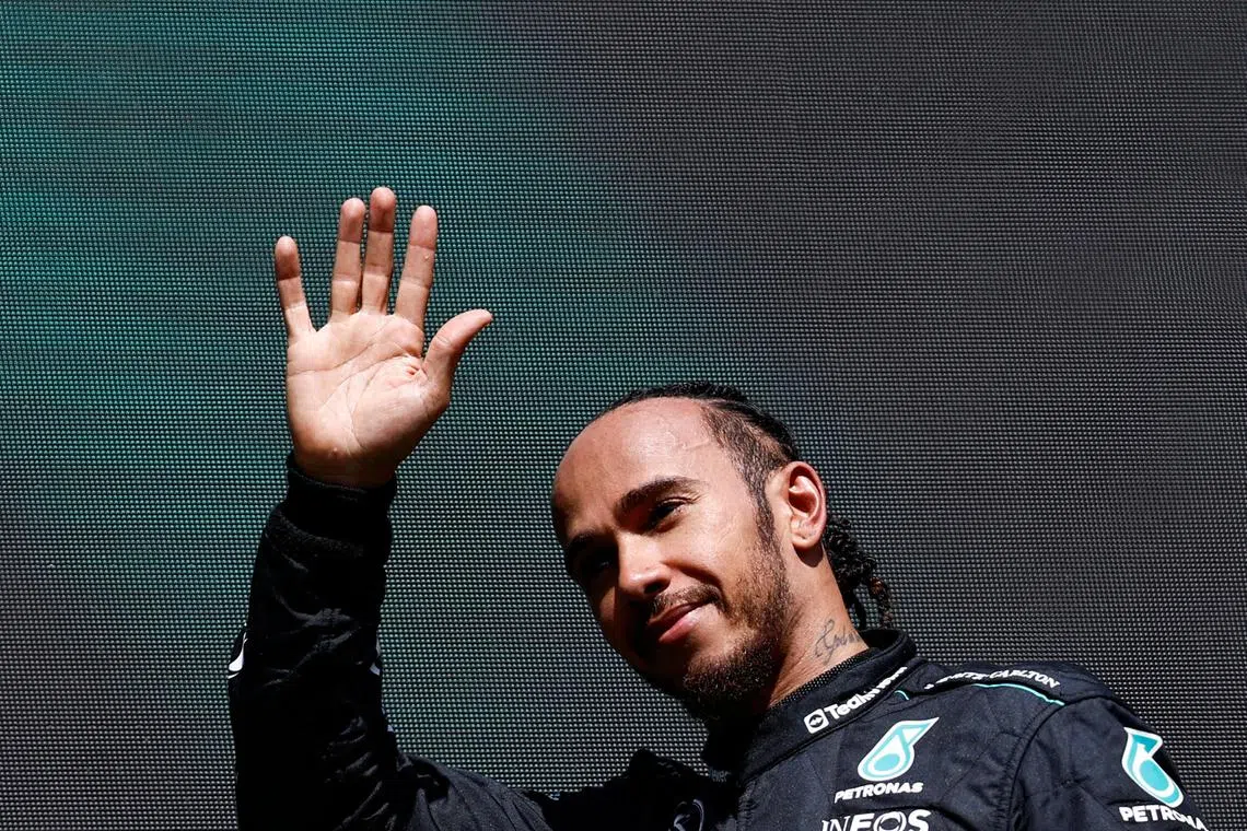 Mercedes' Lewis Hamilton waves as he arrives for the podium ceremony after the Formula One Belgian Grand Prix on July 28.