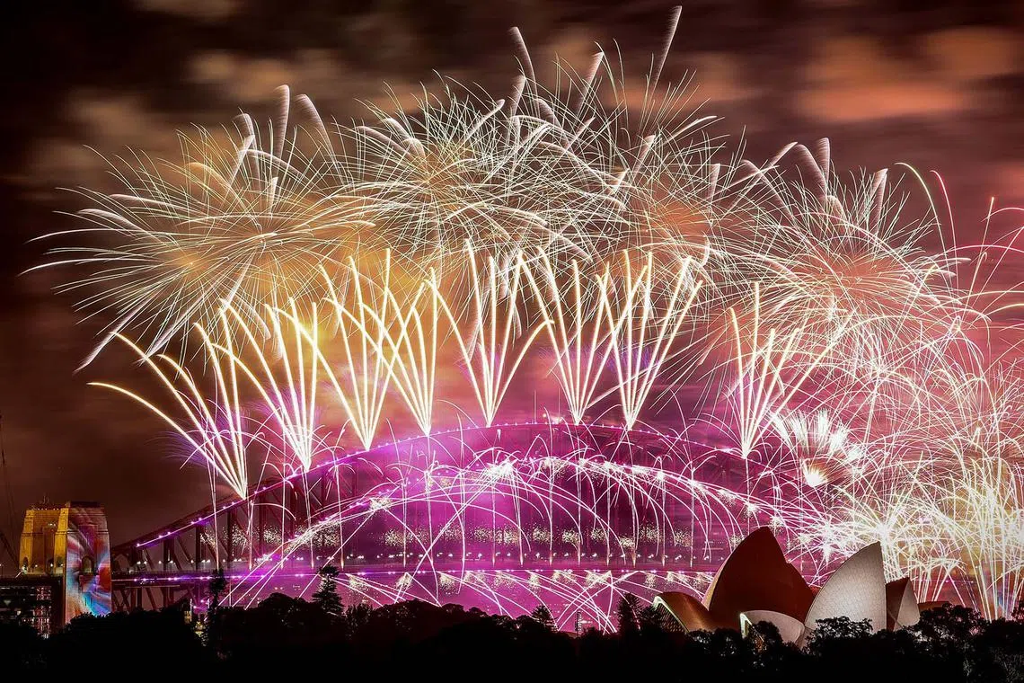 Fireworks exploding over the Sydney Harbour Bridge and Sydney Opera House during New Year celebrations in Sydney on Jan 1, 2024. 