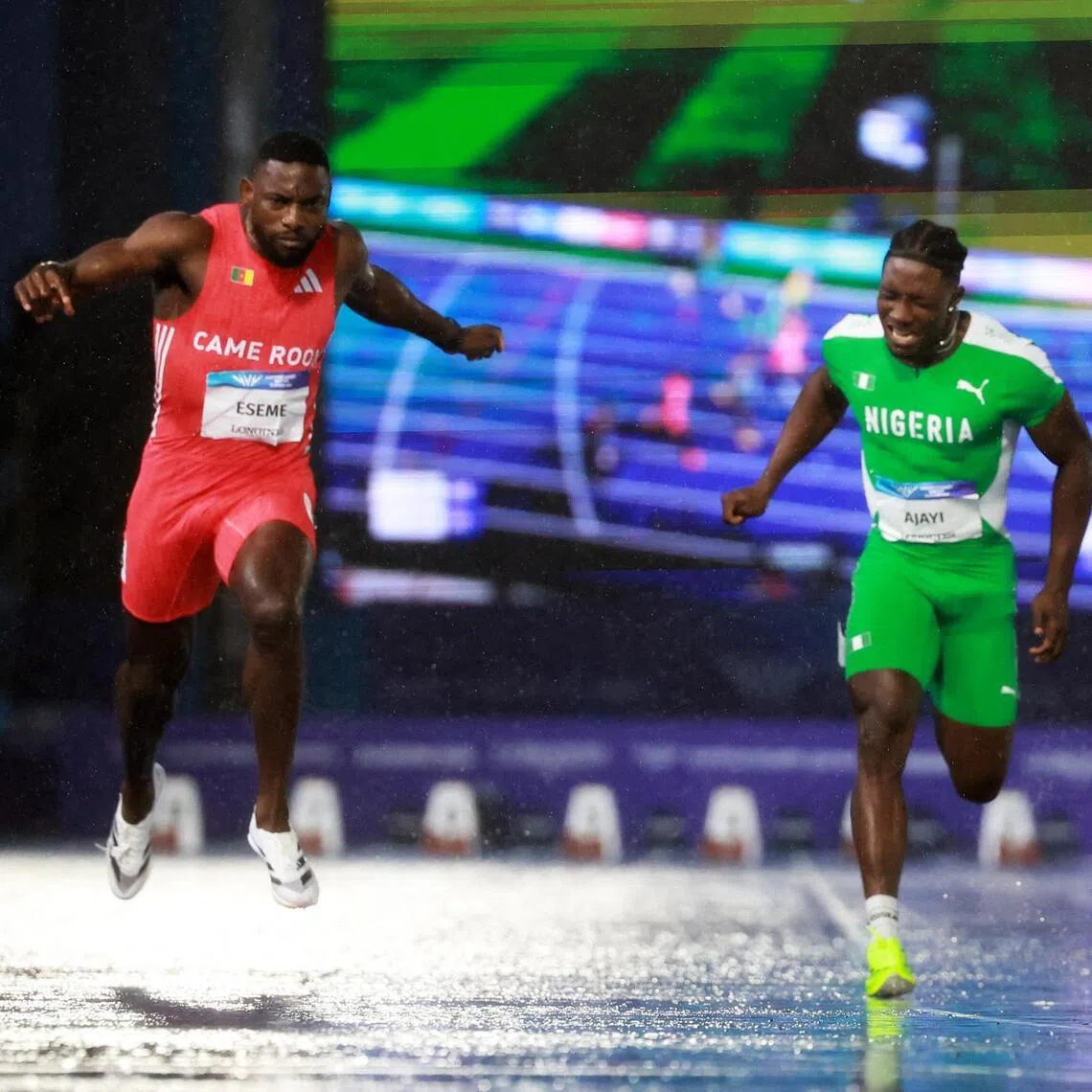 Cameroon’s Emmanuel Eseme (in red) crosses the finish line to win the men’s 100m final at the Commonwealth Games.