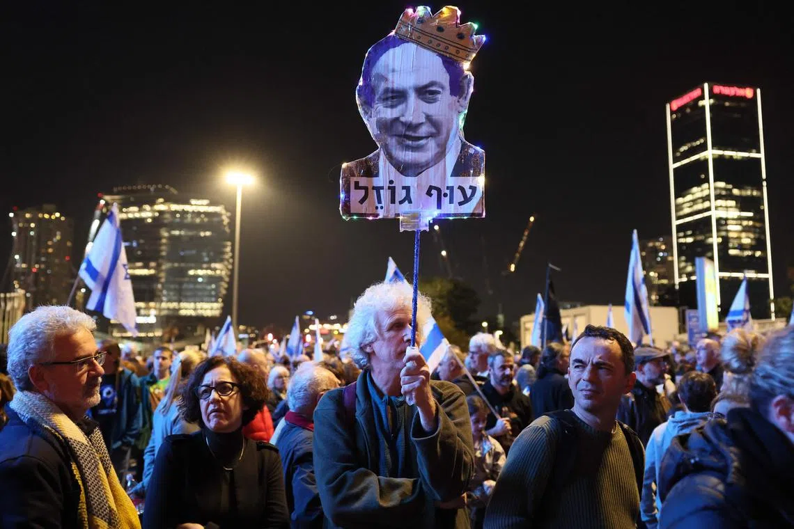An Israeli protester carries a cut out of Prime Minister Benjamin Netanyahu during a demonstration against his new hard-right government in Tel Aviv.