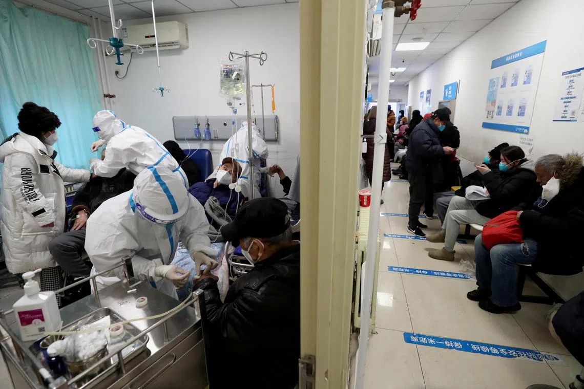 Medical workers in protective suits attending to patients in a hospital in Beijing, on Dec 27, 2022.