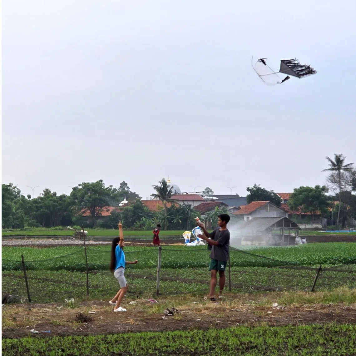 People seen flying kites at a paddy field which is located within 15km of Jakarta’s Soekarno-Hatta international airport's flight operations safety area, a strictly controlled red zone.
