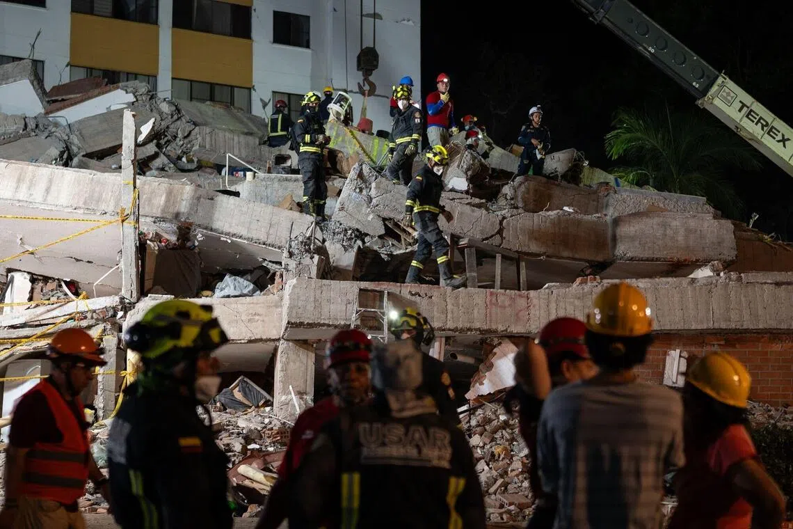 Rescue workers remove rubble from the Cantabria building on Aug 13 following the earthquake in Cali, Colombia.