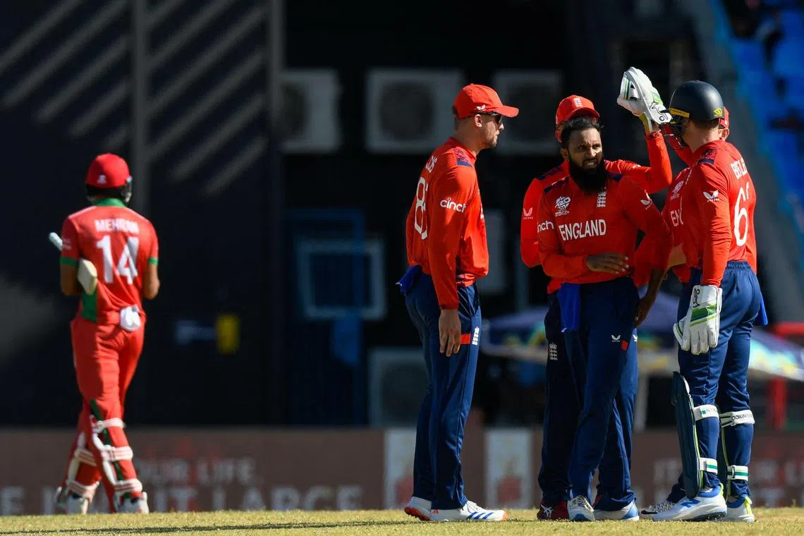 England's Adil Rashid (second from right) celebrating the dismissal of Oman's Mehran Khan (left) in the ICC T20 World Cup match at Vivian Richards Cricket Stadium in North Sound, Antigua and Barbuda, on June 13, 2024.