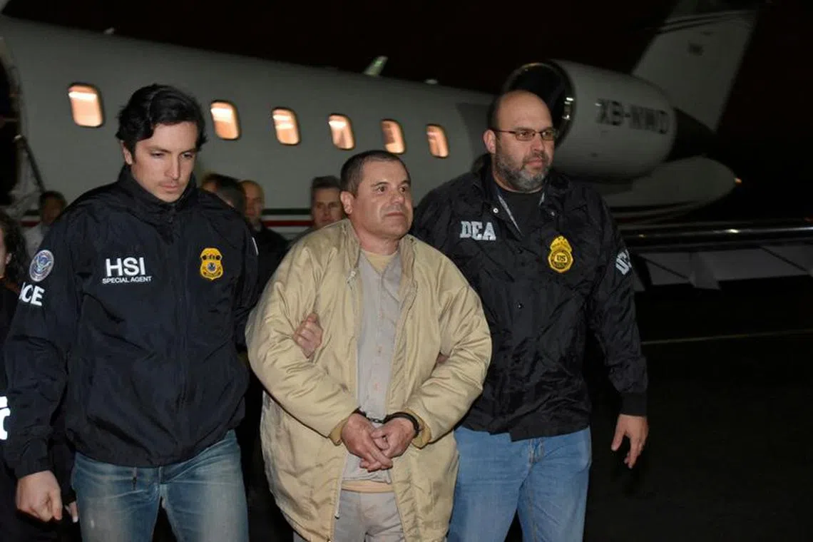 FILE PHOTO: Mexico's top drug lord Joaquin \"El Chapo\" Guzman is escorted as he arrives at Long Island MacArthur airport in New York, U.S., January 19, 2017, after his extradition from Mexico. U.S. officials/Handout via REUTERS/File Photo