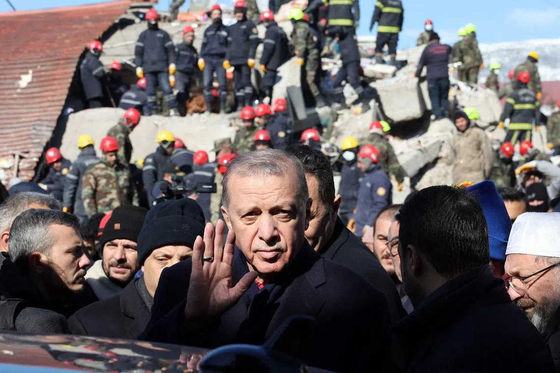 TOPSHOT - Turkish President Recep Tayyip Erdogan tours the site of destroyed buildings during his visit to the city of Kahramanmaras in southeast Turkey, two days after the severe earthquake that hit the region on February 8, 2023. - The death toll from a massive earthquake that struck Turkey and Syria rose above 11,200 on February 8, 2023 as rescuers raced to save survivors trapped under debris in the winter cold. (Photo by Adem ALTAN / AFP)