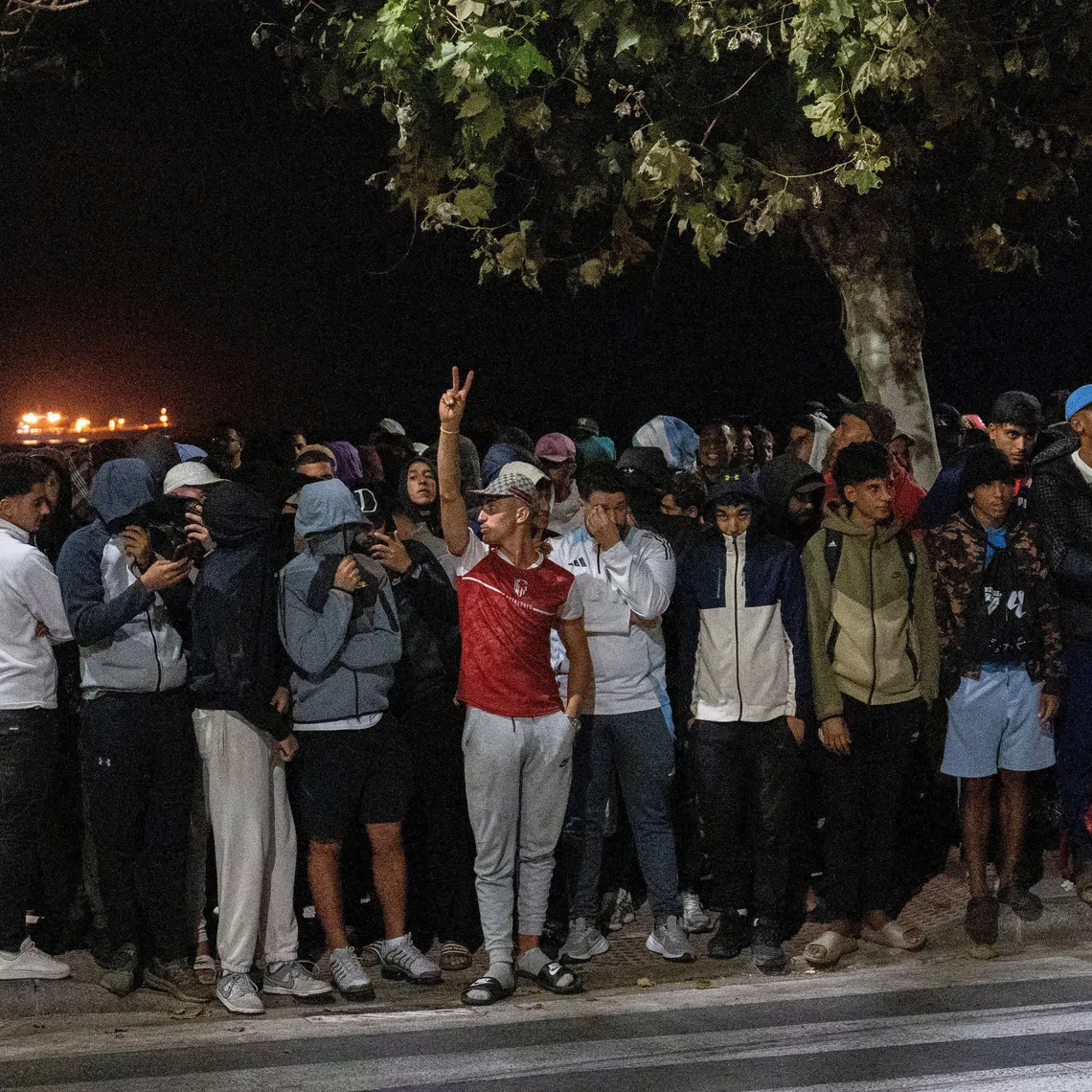 MIgrants gather as Police escort them from Benitez Beach to be relocated to the camp set up at the port of Ceuta, Spain, September 18, 2026. REUTERS/ Anna Surinyach