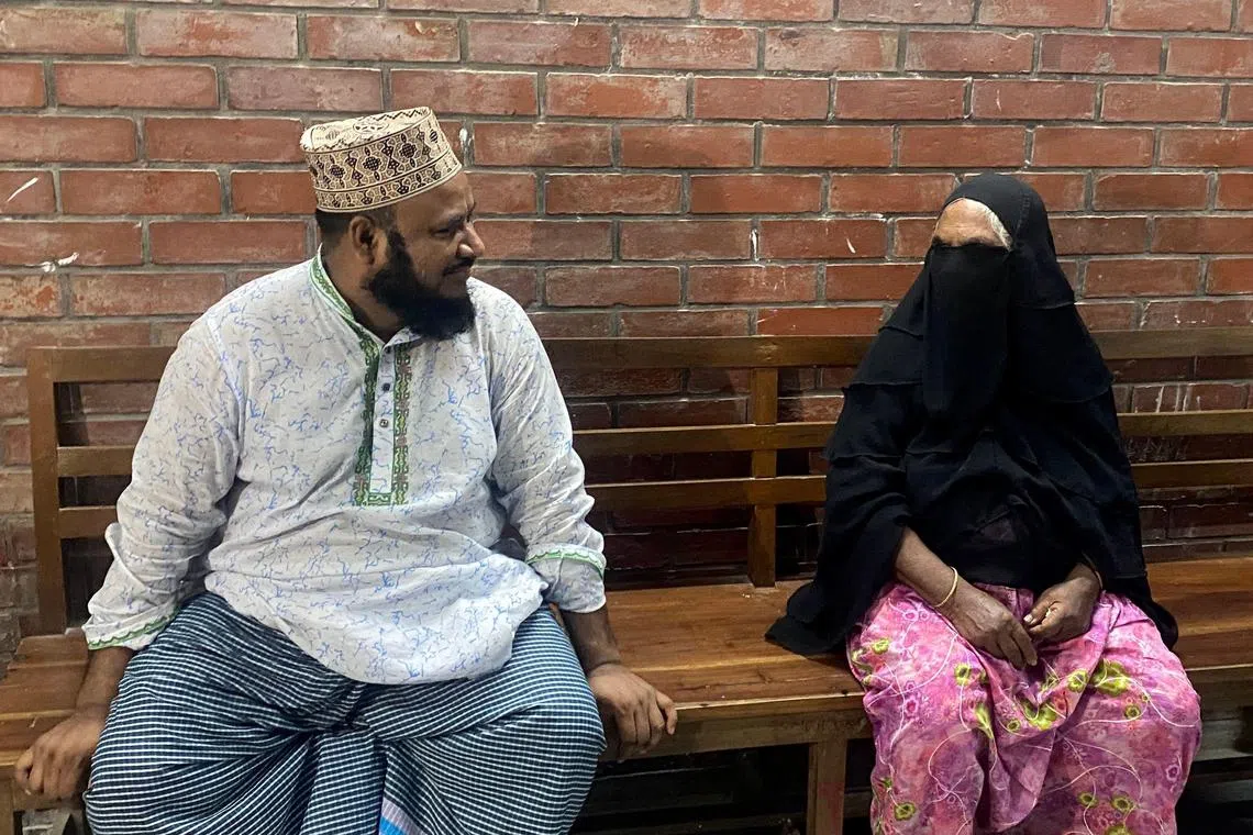 The landlord (left) and sister of hangman Shahjahan Bouya sit at a hospital bench as they wait to receive Bouya’s body after he died in a hospital, in Dhaka on June 24, 2024.