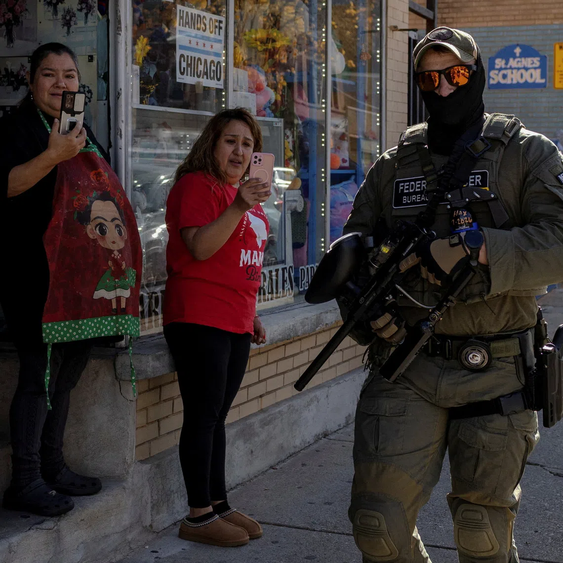 Bystanders film a federal agent in the Little Village neighborhood during a deportation drive, Chicago, Illinois, U.S., November 6, 2025. REUTERS/Jim Vondruska