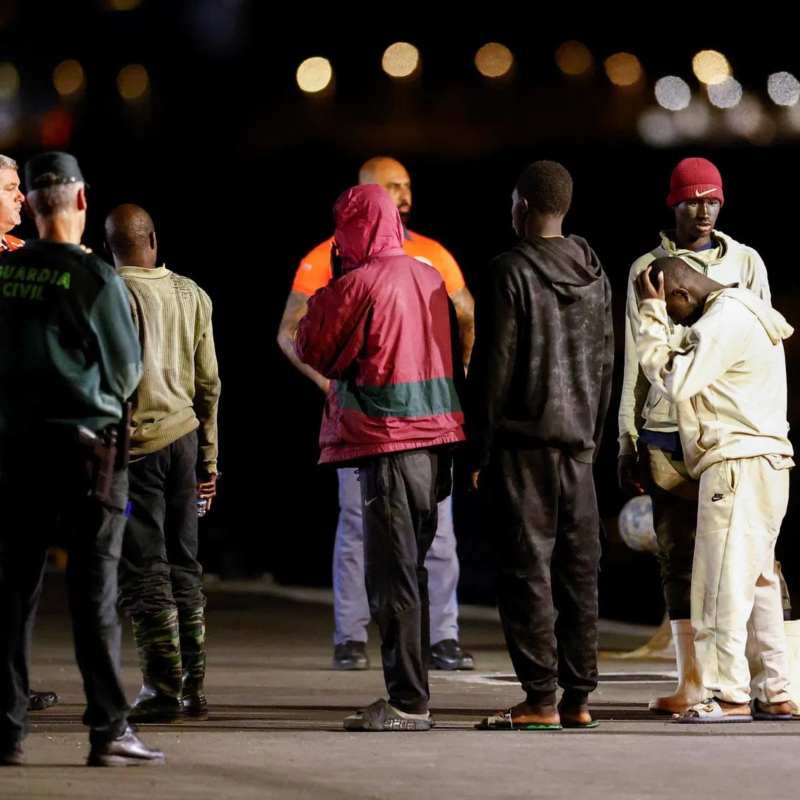 Migrants wait to be attended to after disembarking from a Spanish coast guard vessel at the port of Arguineguin, on the island of Gran Canaria, Spain, April 21, 2026. REUTERS/Borja Suarez