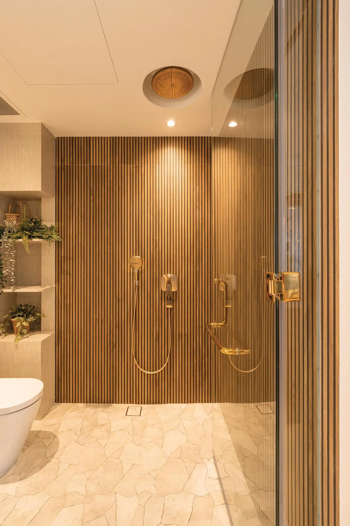 A glass door separates the vanity from the shower and WC.