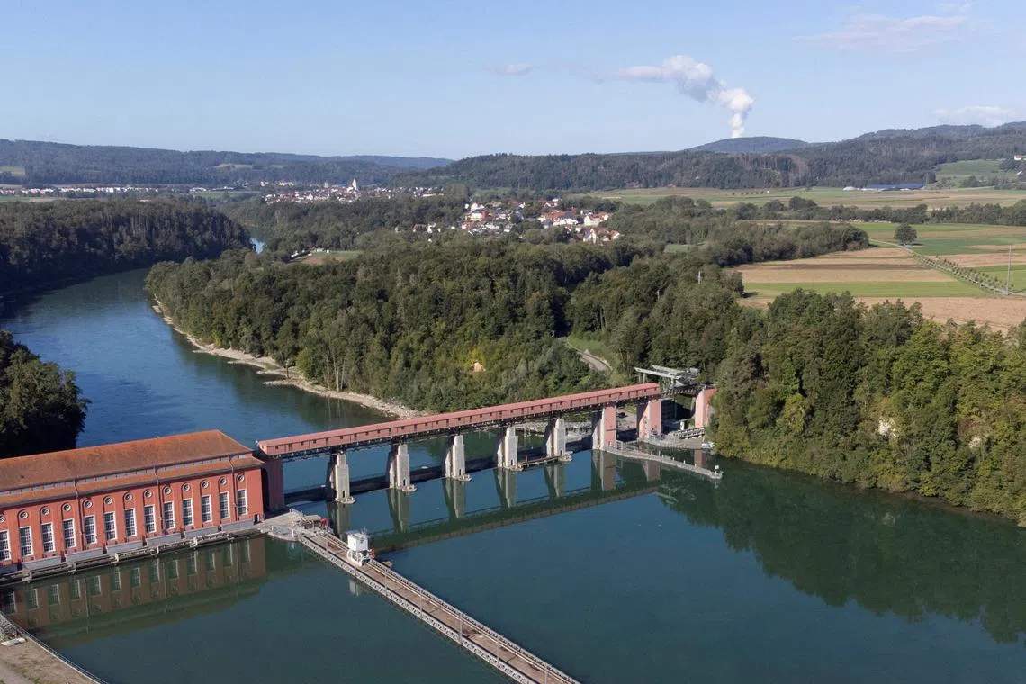 FILE PHOTO: Steam rises from the cooling tower of the nuclear power plant KKW Leibstadt of Swiss energy company Kernkraftwerk Leibstadt AG behind the hydropower plant Eglisau of Swiss Axpo enrergy company and the Rhine river in Rheinsfelden, Switzerland September 20, 2022. REUTERS/Arnd WIegmann/File Photo