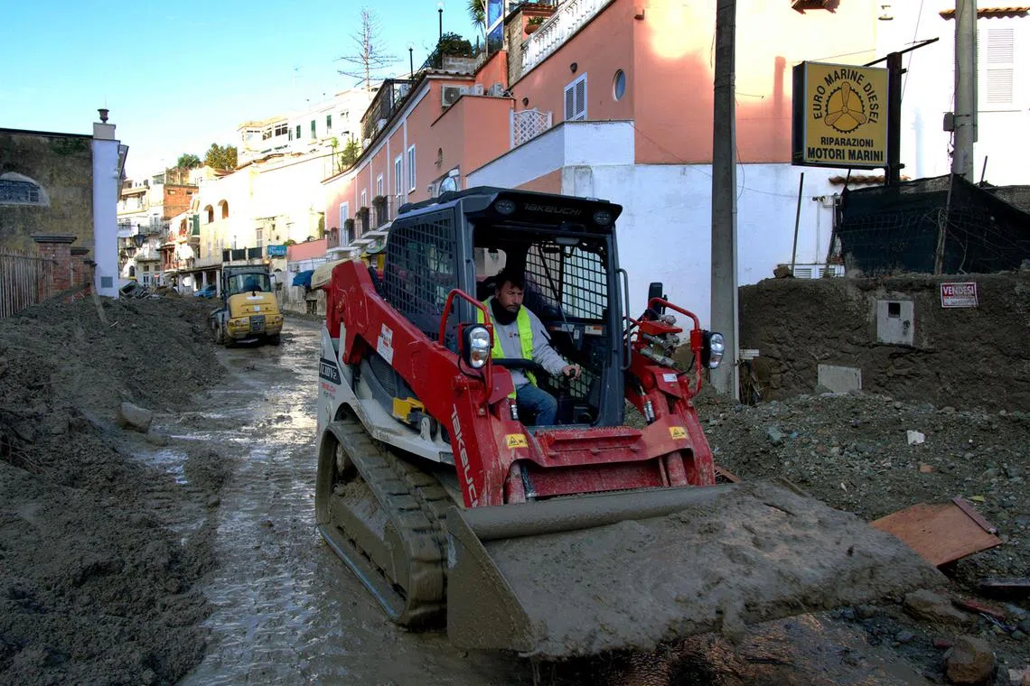 A man uses a tractor to remove mud from a street in Casamicciola on Nov 27, 2022, following heavy rains that caused a landslide on the island of Ischia, southern Italy. 