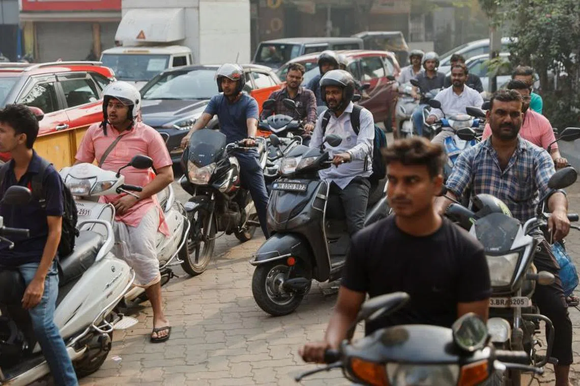 People wait in a queue to refill fuel tanks fearing shortages following a nationwide strike by truckers, which was called off on Tuesday night after talks with the government and demanded revocation of a newly enacted law imposing penalties for hit-and-run accidents, at a petrol pump in Mumbai, India, January 3, 2024. REUTERS/Francis Mascarenhas