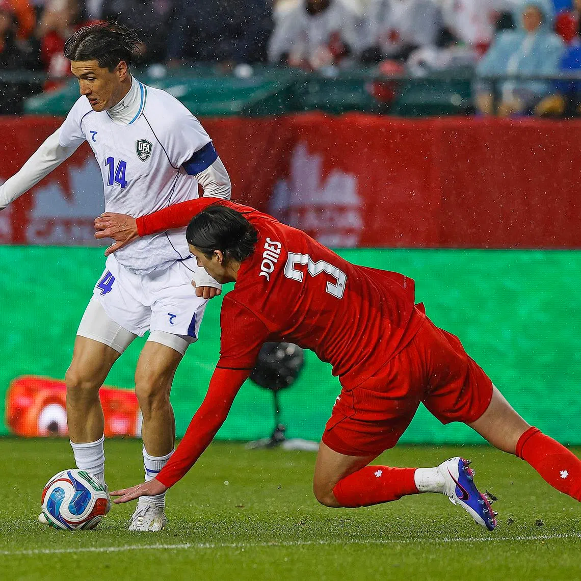 Jun 1, 2026; Edmonton, Ontario, CAN; Uzbekistan forward Eldor Shomurodov (14) carries the ball past Team Canada defender Alfie Jones (3) during the second half at Commonwealth Stadium. Mandatory Credit: Perry Nelson-Imagn Images