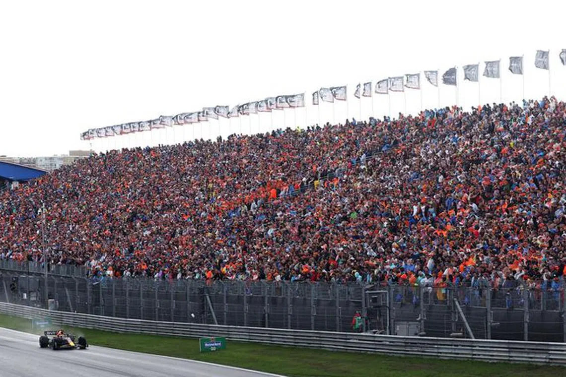 Formula One F1 - Dutch Grand Prix - Circuit Zandvoort, Zandvoort, Netherlands - August 27, 2023 Red Bull's Max Verstappen in action drives past fans during the race  REUTERS/Yves Herman